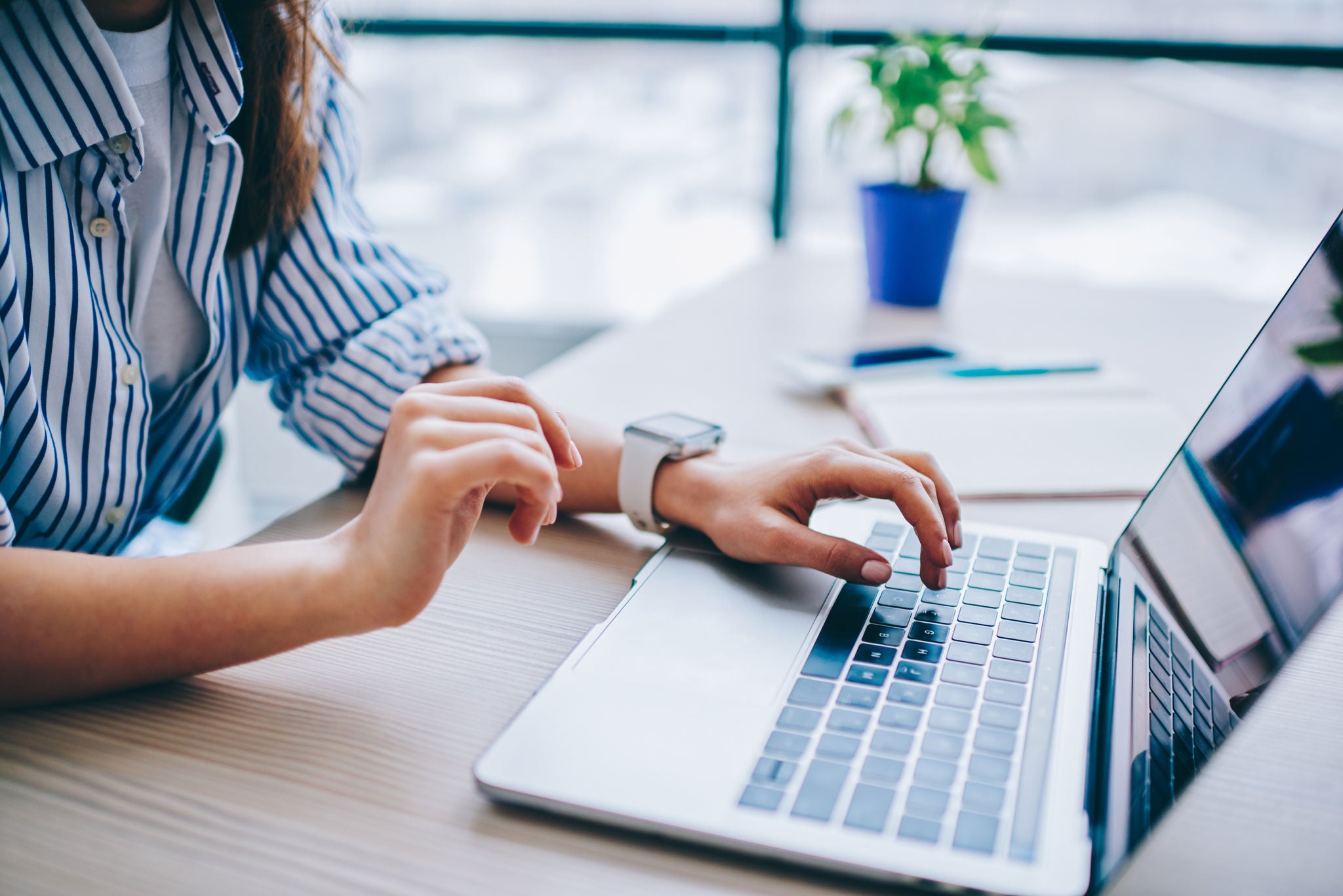Cropped image of female hands searching web information during social networking via modern laptop computer, woman connecting to wifi wireless for making online netbook booking and banking