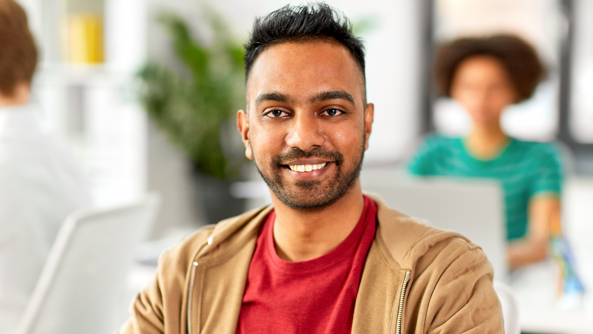 man in office looking into the camera smiling