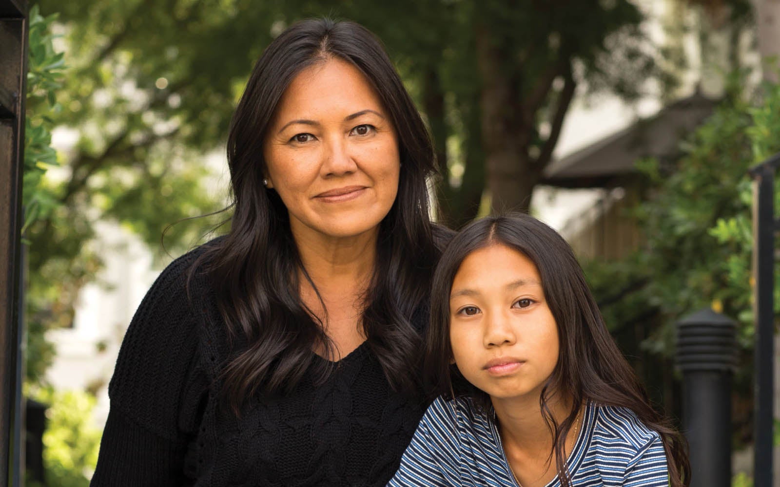 A mother and daughter looking at the camera.