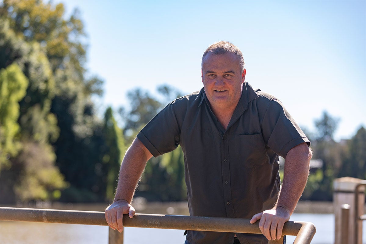 Man standing against a railing outside