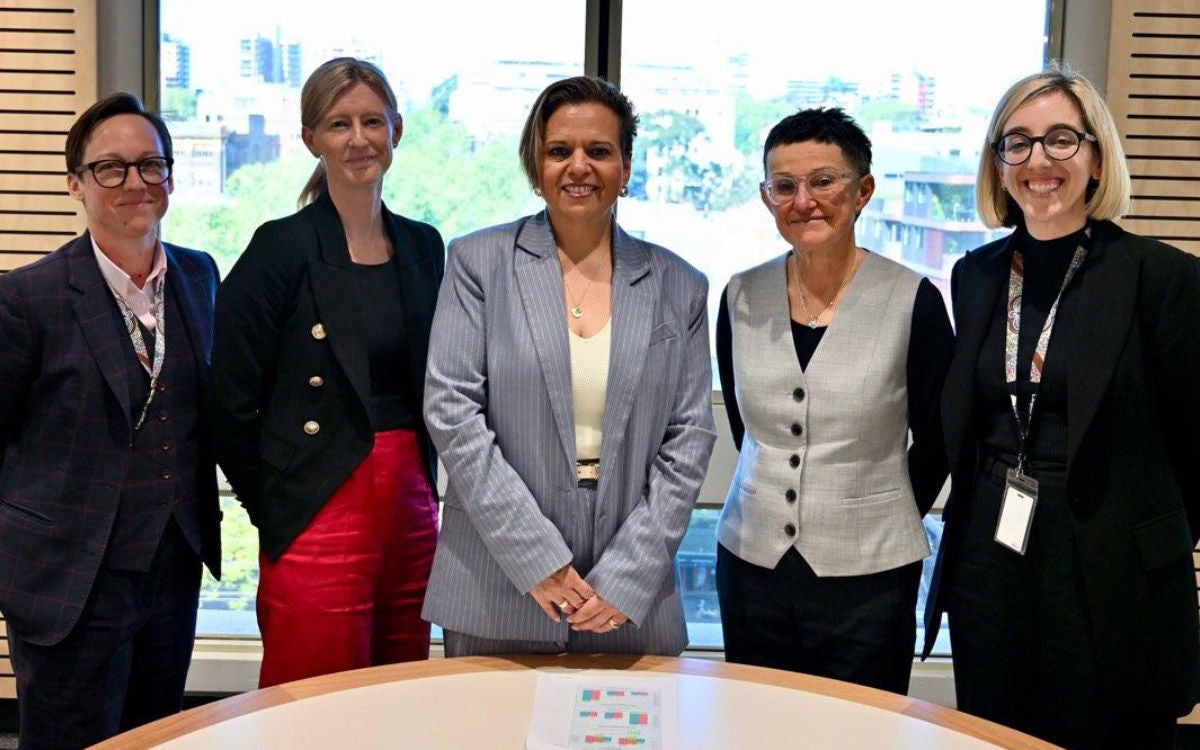 The Commonwealth Attorney-General (centre) standing with Legal Aid NSW staff members during a visit to mark the Domestic Violence Unit's 10-year anniversary. Everyone is happily looking at the camera.